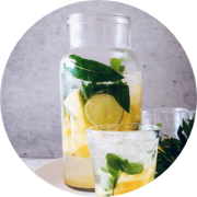 Flasche Wasser mit Zitrusfrüchten und ein Glas
